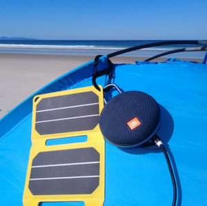 SunSaver Power Flex, 6.4-Watt Solar Charger charging a speaker at the beach camping.